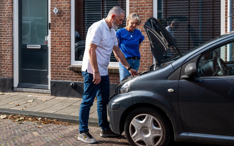 twee mensen die een auto inspecteren tijdens het verkoopproces